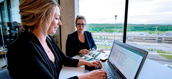Two students work on waste audits on a laptop