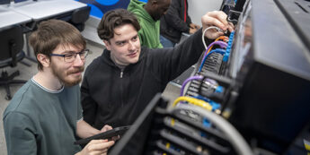 student working with various network cables in a classroom