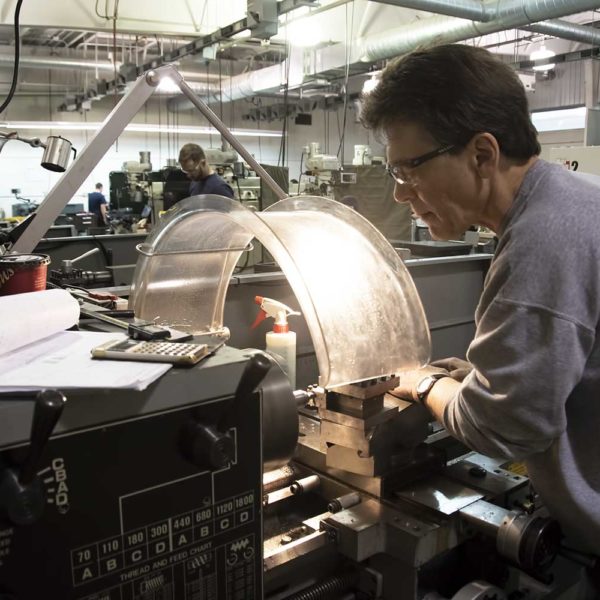 Student works on machining machine