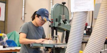 Female student working on a band saw.