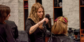 Student cutting hair of a client in the NC Teaching Hair Salon.
