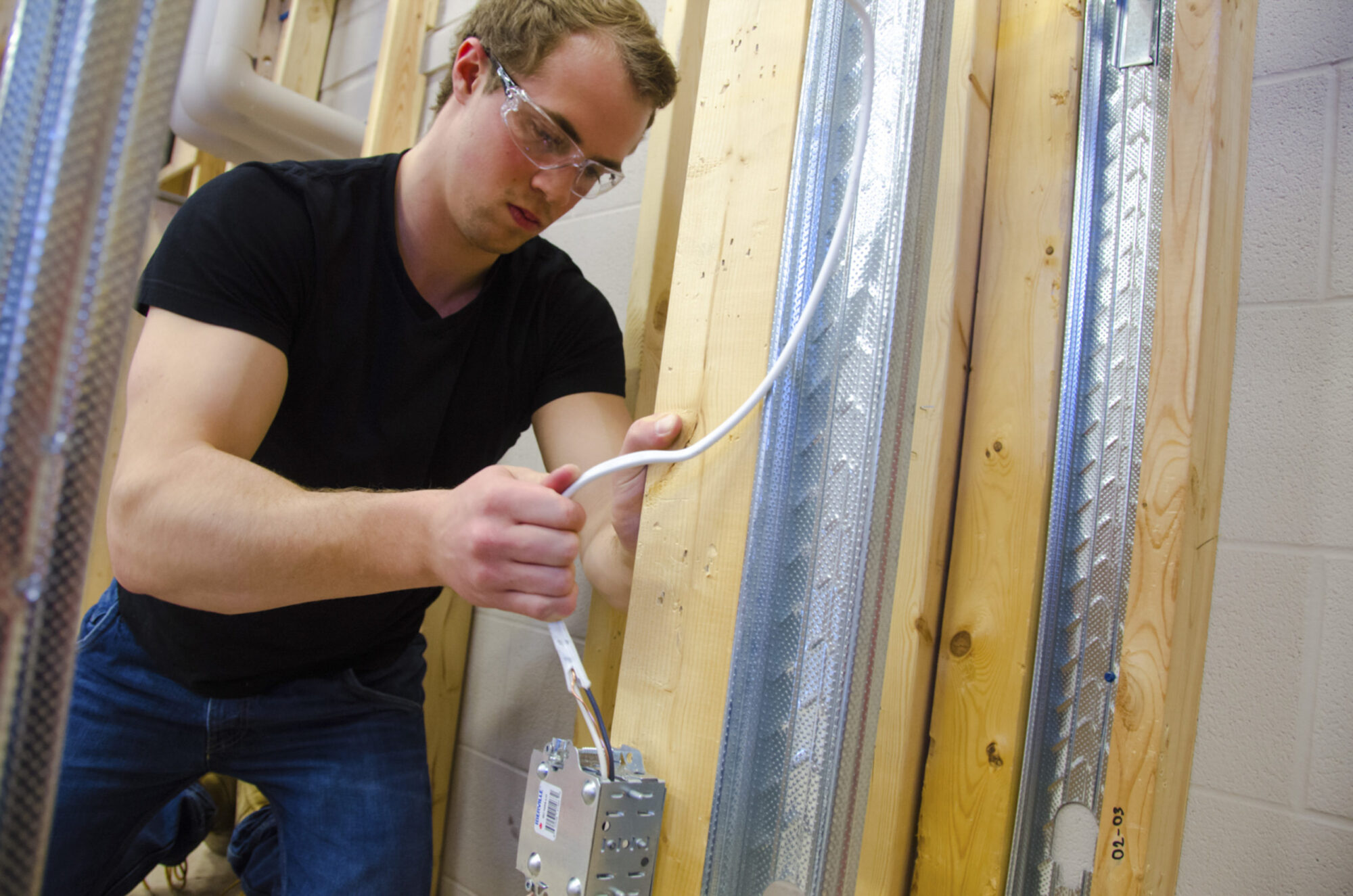 Niagara College Industrial Electrician student works on electrical wires.
