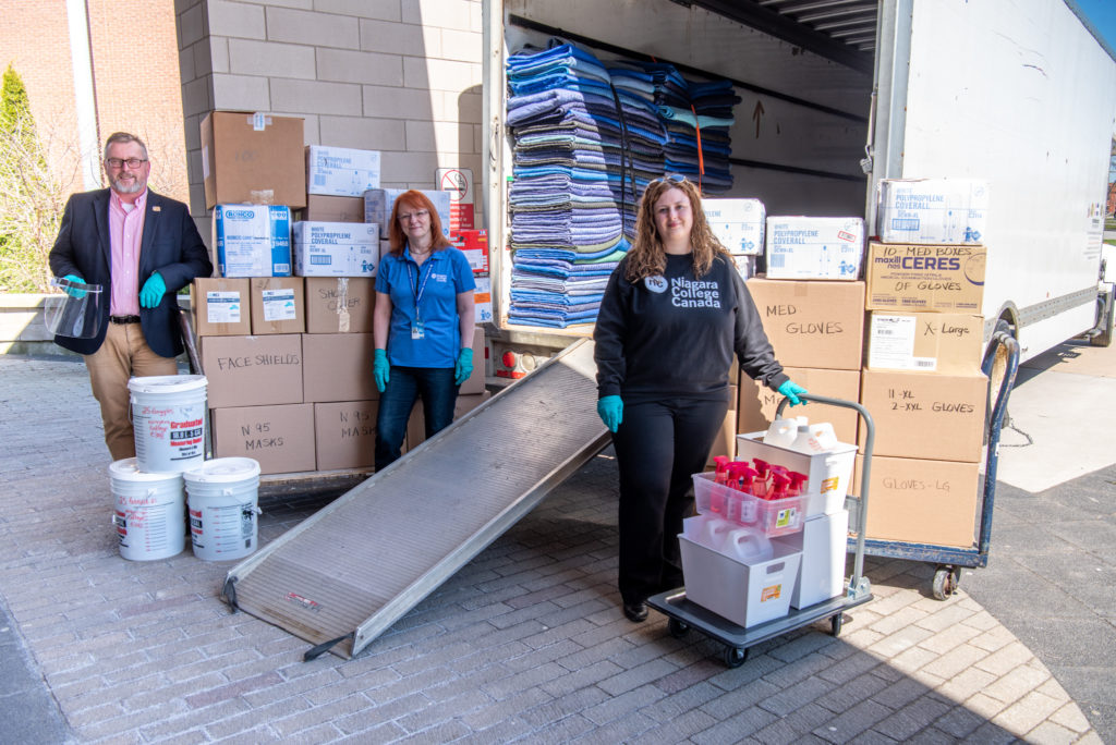 Staff standing near boxes of equipment and truck