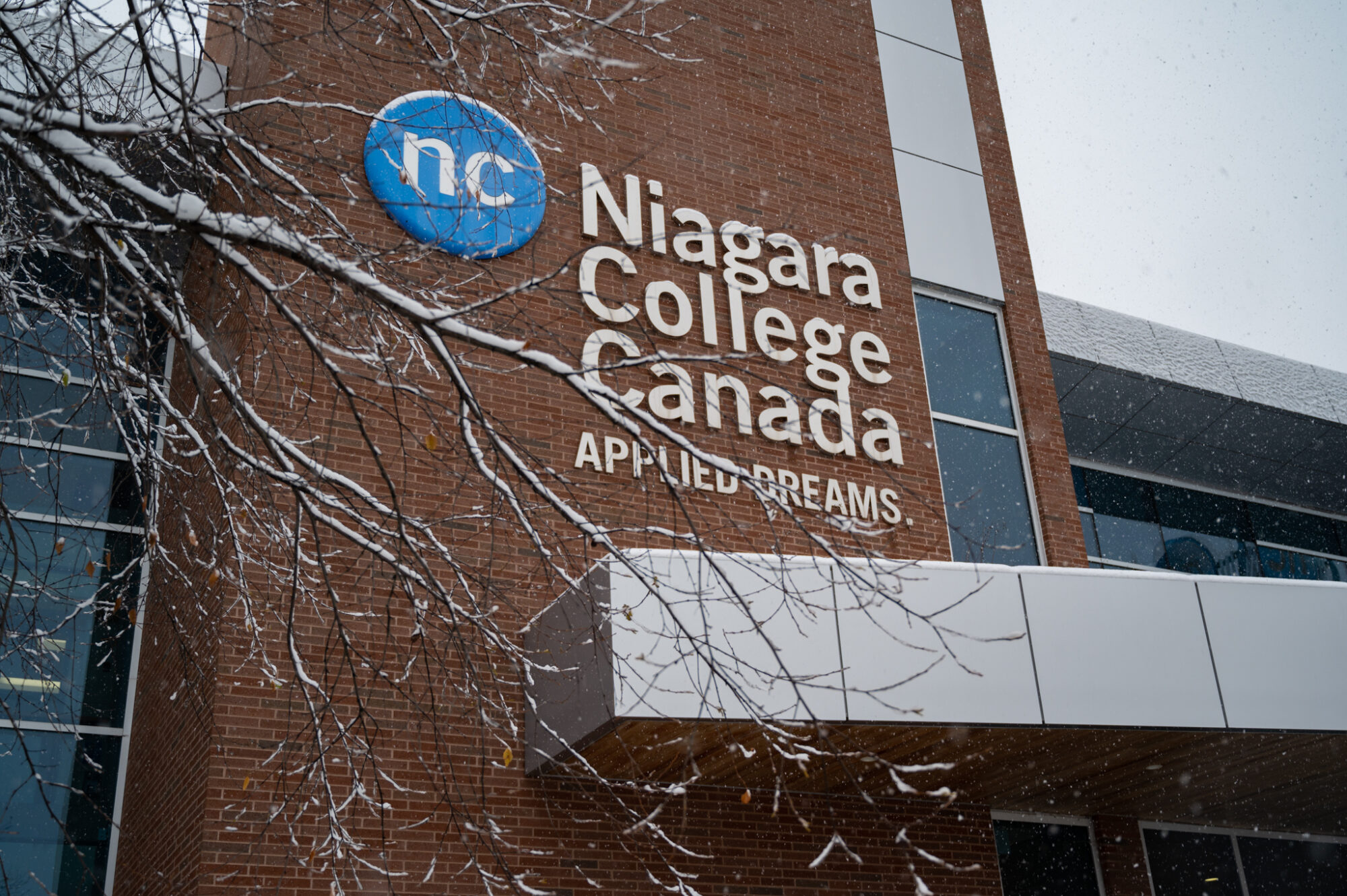 Snowy image of campus building and logo