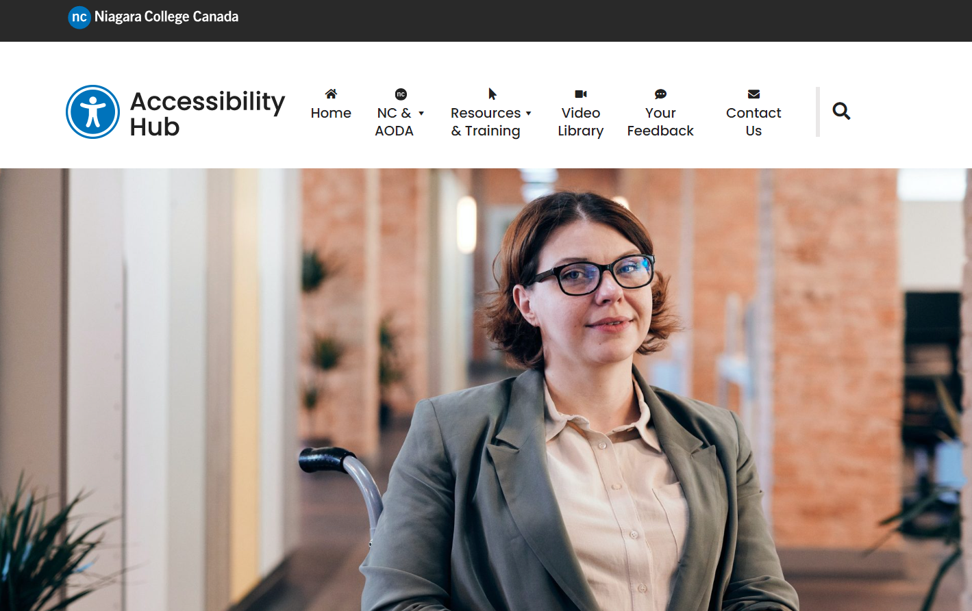 A screenshot of the Accessibility Hub homepage. It features the logo in the top left-hand corner, navigation items across the top of the screen, and a photo of a woman with brown hair and glasses. She is seated in a wheelchair.