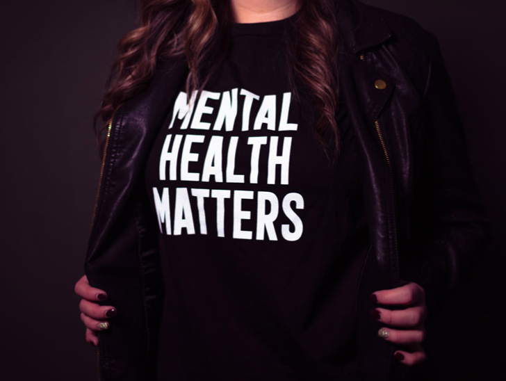 A person wearing a black t-shirt with white text that reads "Mental health matters"