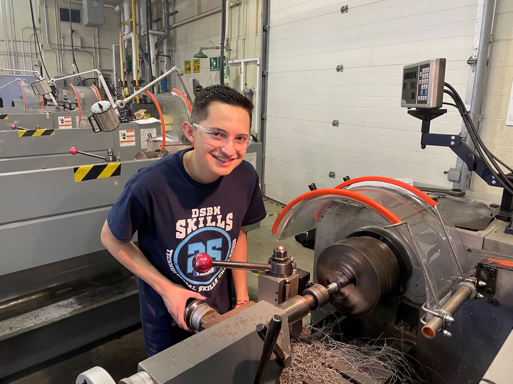 a student operates precision machining equipment