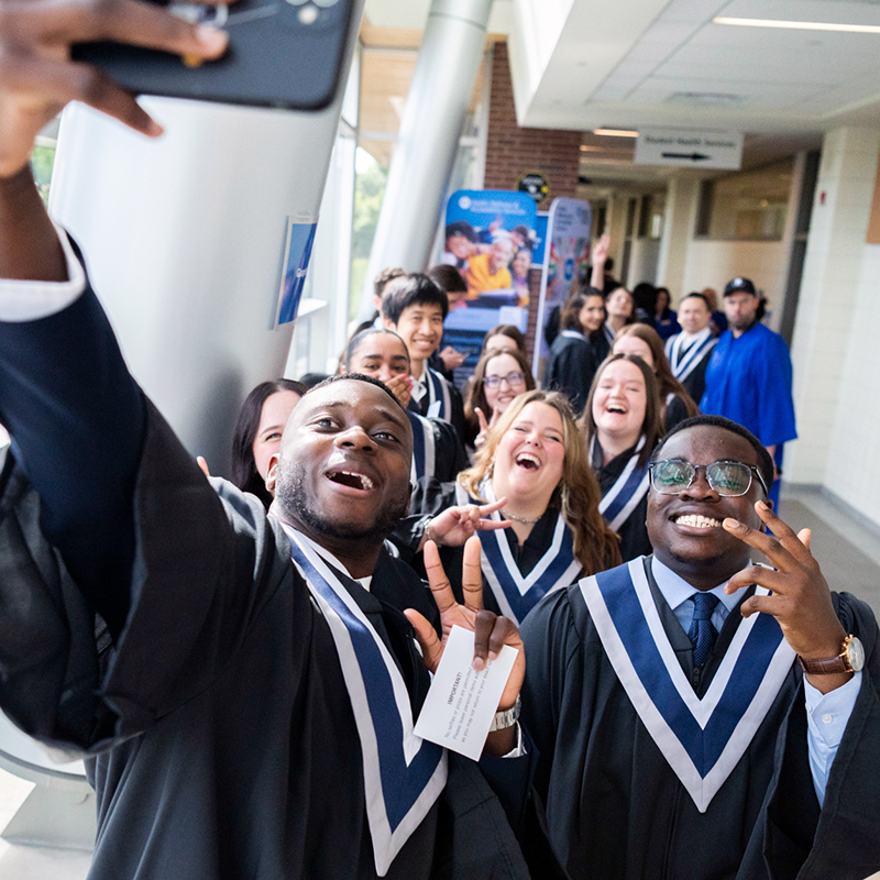Graduates laughing and taking a selfie