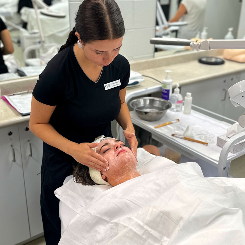 Spa client receives a relaxing facial from NC Esthetician student