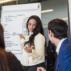 Woman in sharp business attire directs a meeting