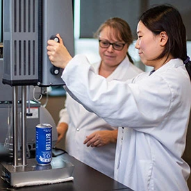 Student in blue lab coat test NC beer