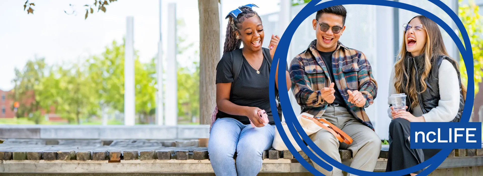 3 students sitting outside of Niagara College laughing.