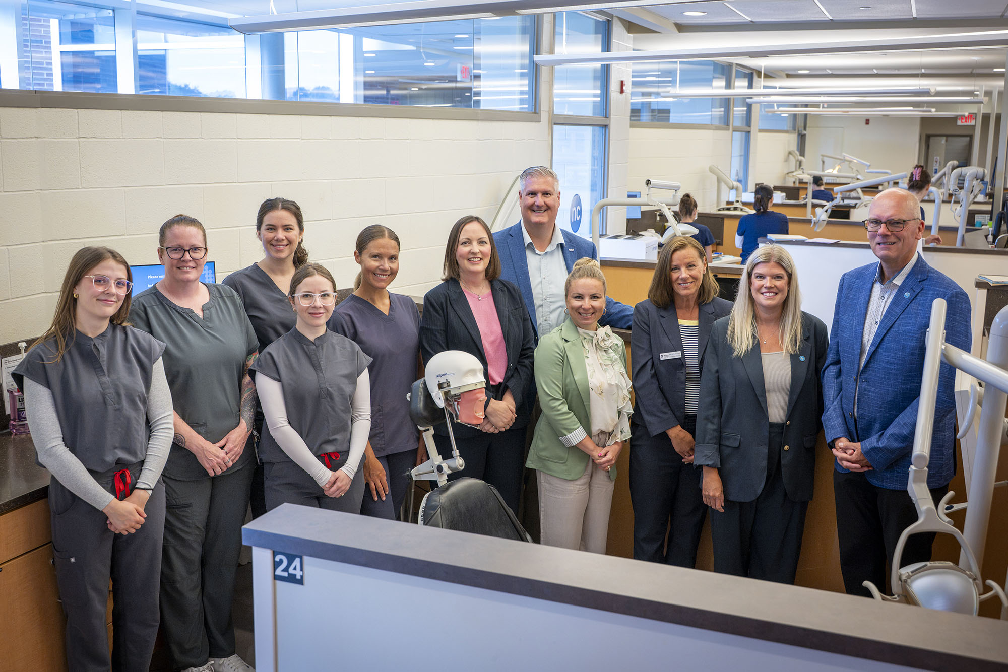 a group of people stand together in a dental clinic