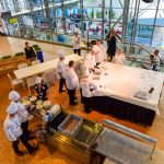 The team sets up the presentation table on the mezzanine where they will present the Edible Buffet.