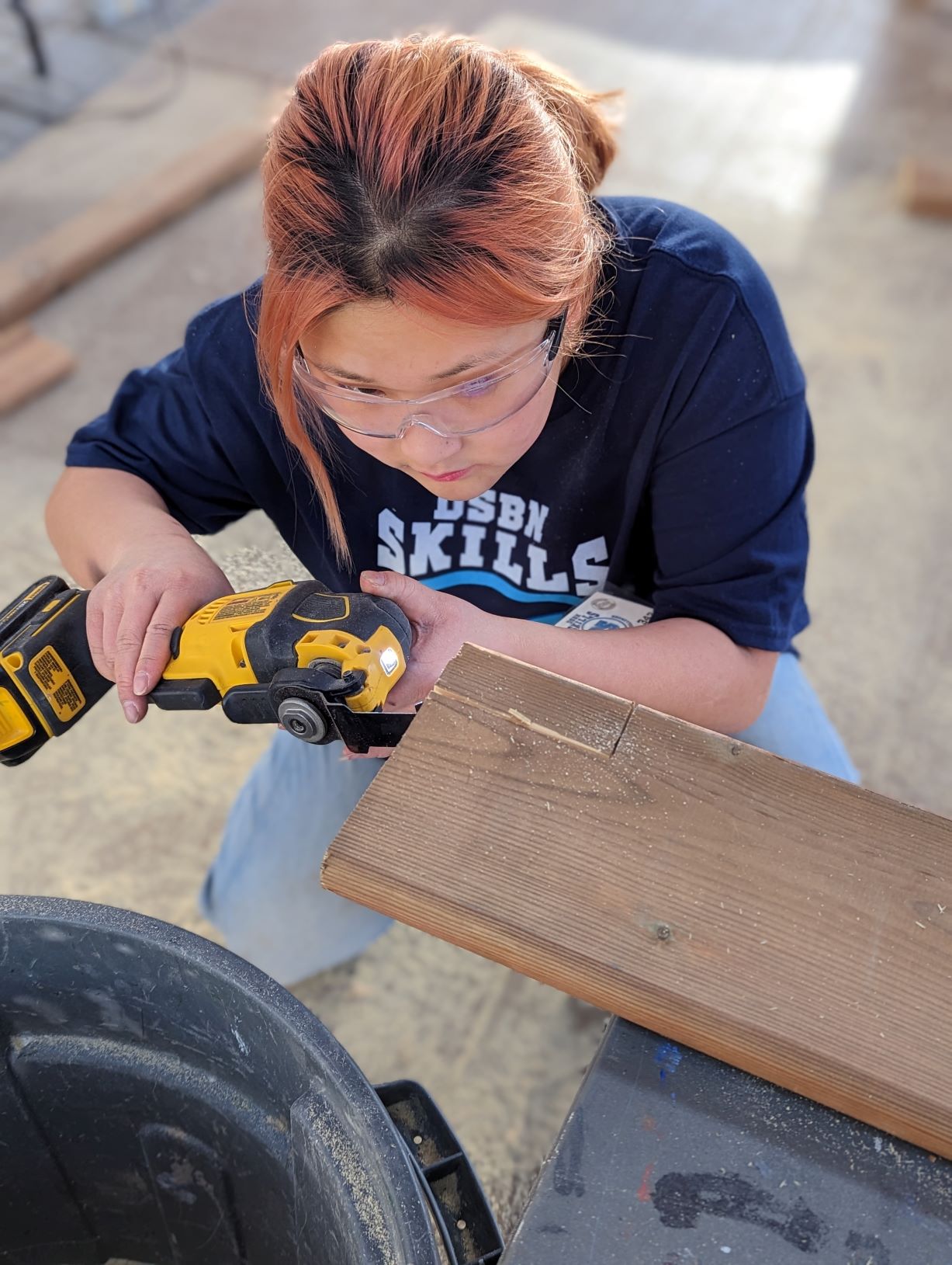 a student operates a saw in a construction lab