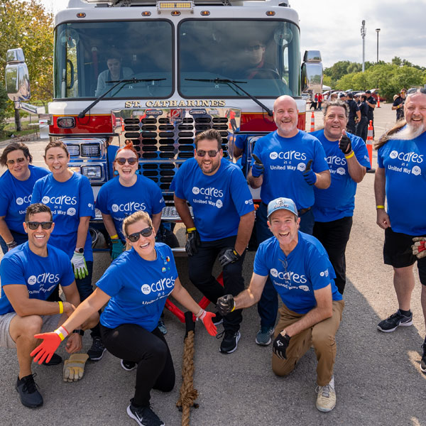 NC staff members posing in front of fire truck wearing NC United Way t-shirts